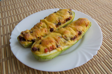 Zucchini boat with chicken, beans and vegetables under cheese