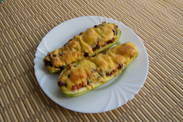 Zucchini boat with chicken, beans and vegetables under cheese