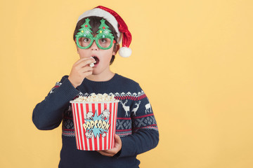 Surprised child Wearing Christmas Hat with popcorn