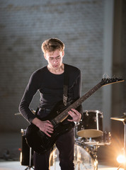 Fototapeta premium A musician man playing guitar and looking at his hands