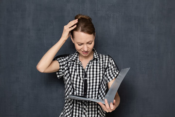 Portrait of frustrated upset girl looking at documents