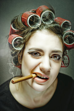 Dangerous Stuff. Funny female portrait with big cigar and  big hair curlers