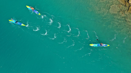 Aerial top down photo of Stand Up Paddle or SUP surfers in tropical exotic lake