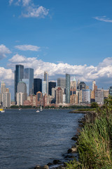 Fototapeta premium Lower Manhattan skyline with boat and ferry on Hudson river view from Liberty State Park in late summer