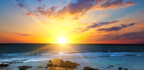 Beach of the ocean and red sunrise. Wide photo.