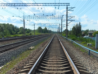 Fototapeta premium Perspective of railroad tracks going beyond the horizon on a bright sunny day