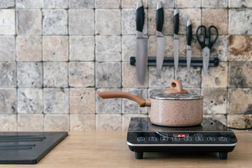 Pan at small electric stove with control panel in kitchen