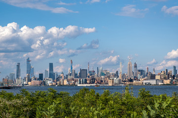 Lower Manhattan skyline with boat and ferry on Hudson river view from Liberty State Park in late summer