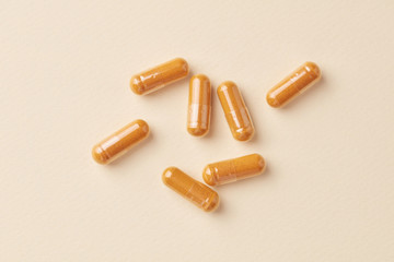 Turmeric capsules. Bright paper background. Top view. Copy space. 