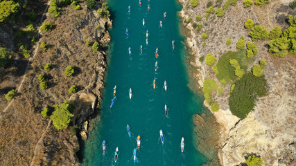 Aerial bird's eye view photo taken by drone of stand up paddle surfers in annual SUP crossing competition in Corinth Canal, Greece