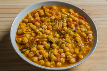 Cooked chickpea with vegetables isolated in a wooden table