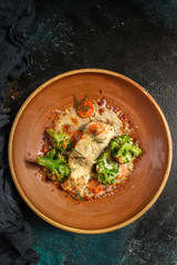 fish baked with vegetables (main course, white fish seafood, broccoli, carrots and others) menu concept. food background. copy space. Top view