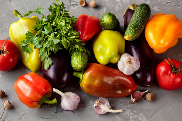 Autumn vegetables (bell pepper, eggplant, tomatoes, garlik, cucumbers)  on a grey grundge background. The concept of healthy and diet food.