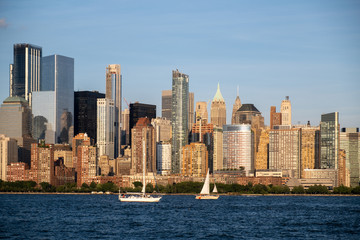 Obraz premium Lower Manhattan skyline with boat and ferry on Hudson river view from Liberty State Park in late summer