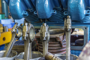 The connecting rod, piston and cylinder block in a disassembled condition in a car workshop.