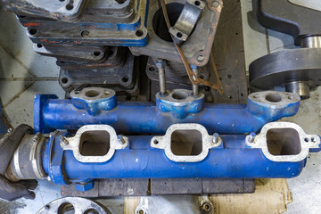 The connecting rod, piston and cylinder block in a disassembled condition in a car workshop.
