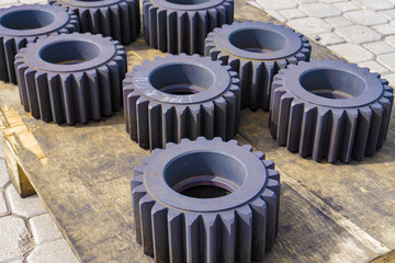 Gear after heat treatment and hardening on a wooden rack, improving the hardness of the metal.
