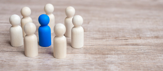 blue leader businessman with circle of wooden men. leadership, business, team, and teamwork concept