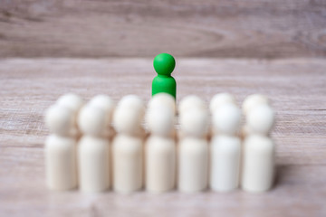 Green leader businessman with crowd of wooden men. leadership, business, team, teamwork and Human resource management concept