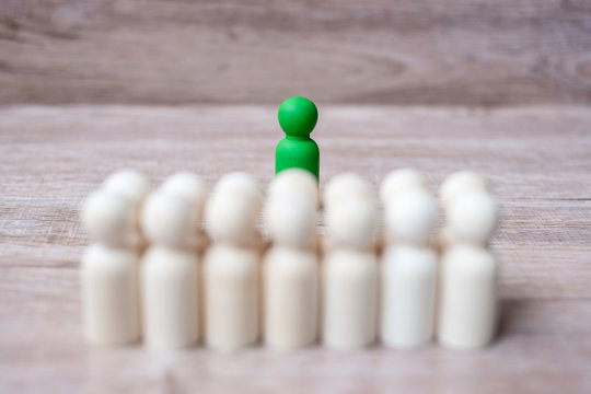 Green leader businessman with crowd of wooden men. leadership, business, team, teamwork and Human resource management concept