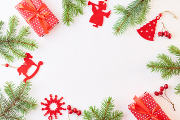 Flat lay frame with evergreen tree branch, christmas decorations and gift box on a white background