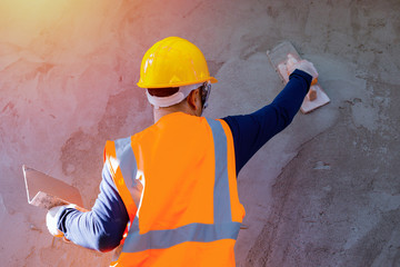 Workers plastering the wall indoors,Workers on the construction site, construction sites against the sunset