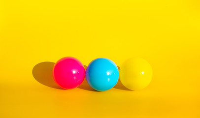 Colorful balloon with shadow on yellow color background