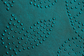 Texture of genuine leather with rivets close-up, green mint color, for wallpaper or banner design. For modern background