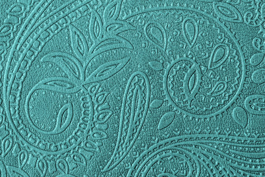 Texture of genuine leather with embossed floral trend pattern close-up, green mint color, for wallpaper or banner design. For modern background
