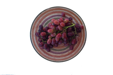 bunch of grapes on a plate of isolate on a white background.