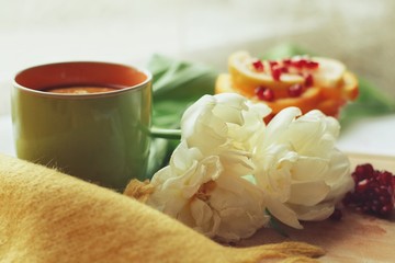 Tender white flower and cup of tea with pomegranate
