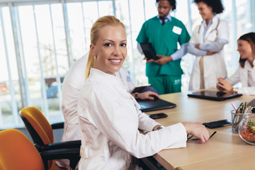 Fototapeta premium Portrait of attractive female doctor on hospital looking at camera smiling.