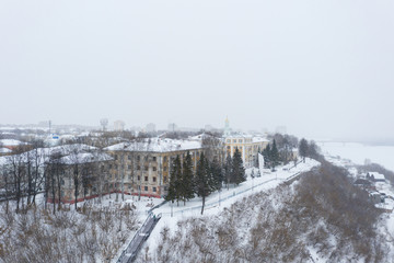 Kirov and the high bank of the river Vyatka and the Alexander Grin Embankment and Trifonov Monastery on a cloudy winter day.