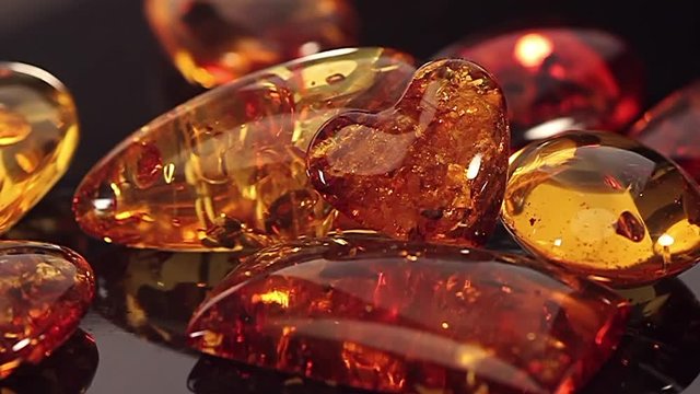 Amber heart pendant on the black background