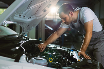 Mechanic working on a car in auto repair shop