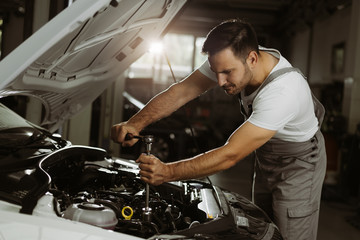 Fototapeta na wymiar Mechanic is repairing an engine in the auto repair shop