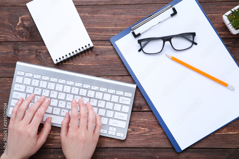 Fototapete female hands typing on computer keyboard with blank sheet of paper and glasses