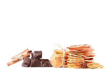 Dried citrus fruits with cinnamon, star anise and chocolate on white background