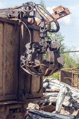 Mechanical grabbing arm manipulator on construction site for the removal of construction waste. A mechanical arm for moving goods.