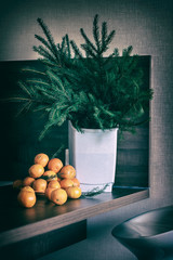 Fresh tangerines on a wooden table with coniferous branches of spruce. Christmas composition, winter holiday. Vintage dark background