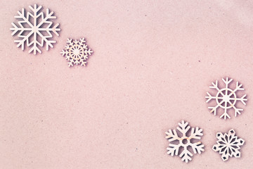 Abstract pink christmas background, cardboard paper texture with wooden snowflakes. Vintage backdrop, copy space