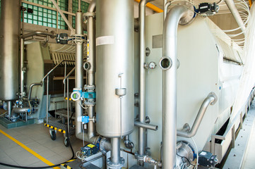 Equipment for preparation of beeer..Lines of metal tanks in modern brewery. Manufacturable process of brewage. Mode of beer production. Inside view of modern brewhouse with stainless barrels