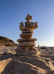 Fototapeta na wymiar Stack of stones in balance on the beach of Trafalgar Lighthouse. Cádiz, Andalusia. Spain