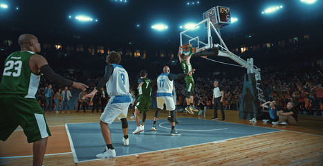 Basketball players on big professional arena during the game. Tense moment of the game. Celebration