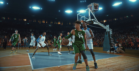 Basketball players on big professional arena during the game. Tense moment of the game. Celebration