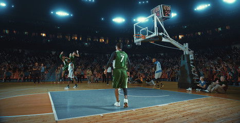 Basketball players on big professional arena during the game. Tense moment of the game. Celebration