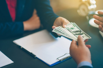 Businessmen give money to each other.Dollar currency