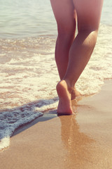 Female legs on a wave background
