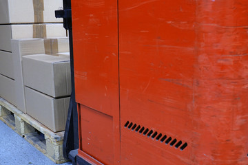Cardboard boxes and forklift in the warehouse. Close up rear view with space for text.