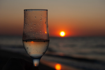 Glass of wine on sunrise, sunset background
